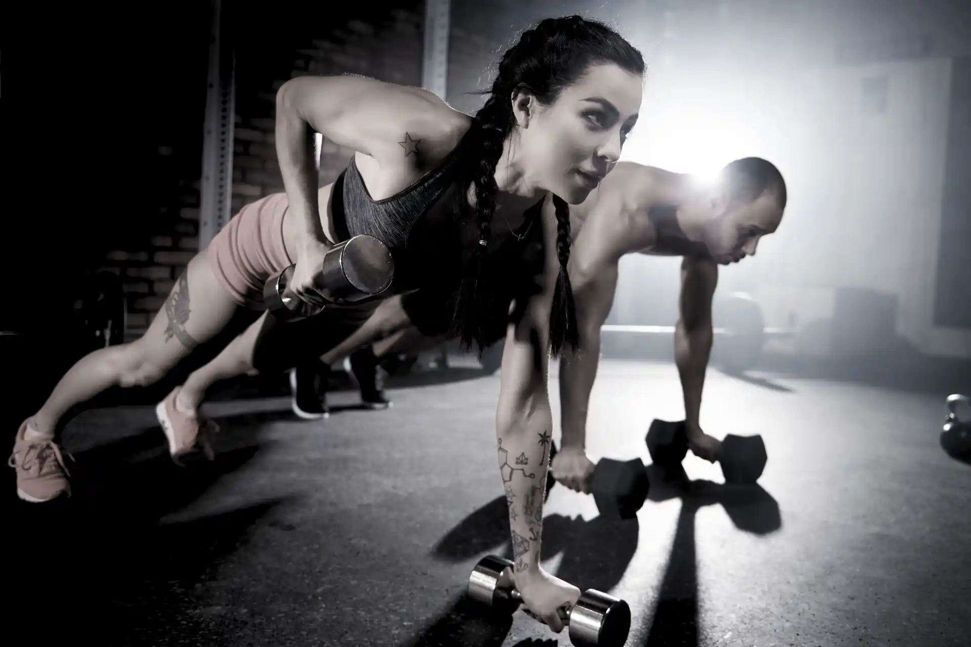 Woman and Man Doing Plank with Dumbbells